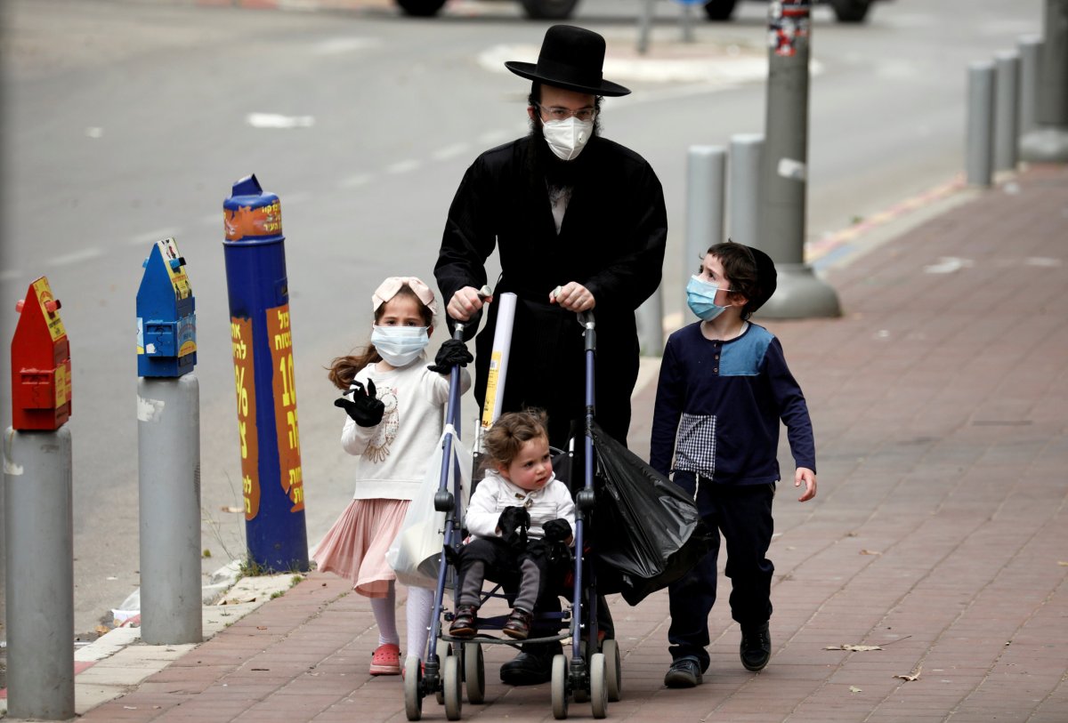 FILE PHOTO: An ultra-Orthodox Jewish family wearing masks walk on