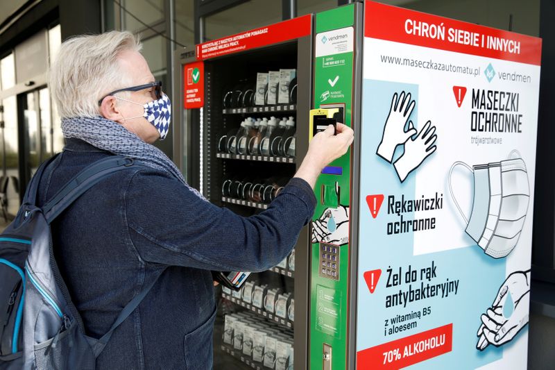 A man uses a vending machine for face masks, gloves