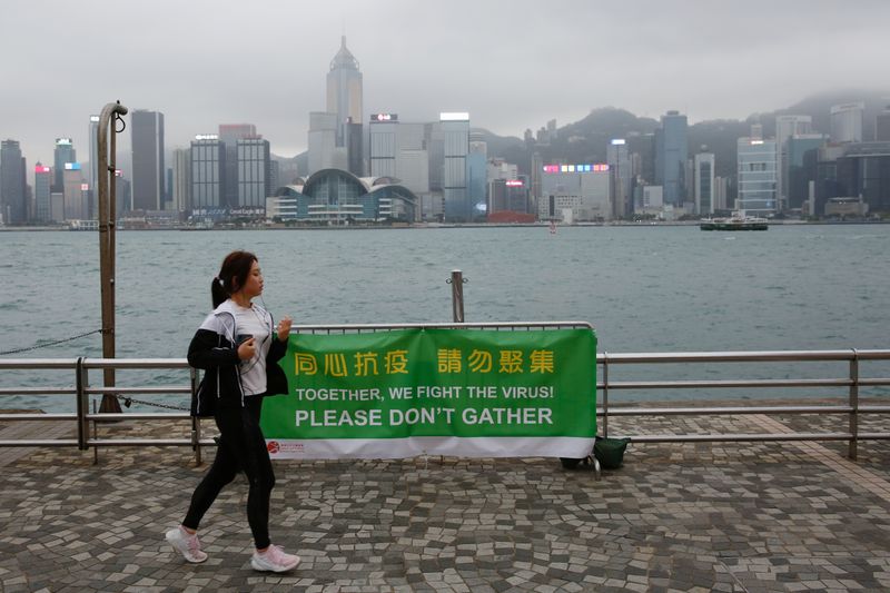 A woman runs past a banner of health advice at