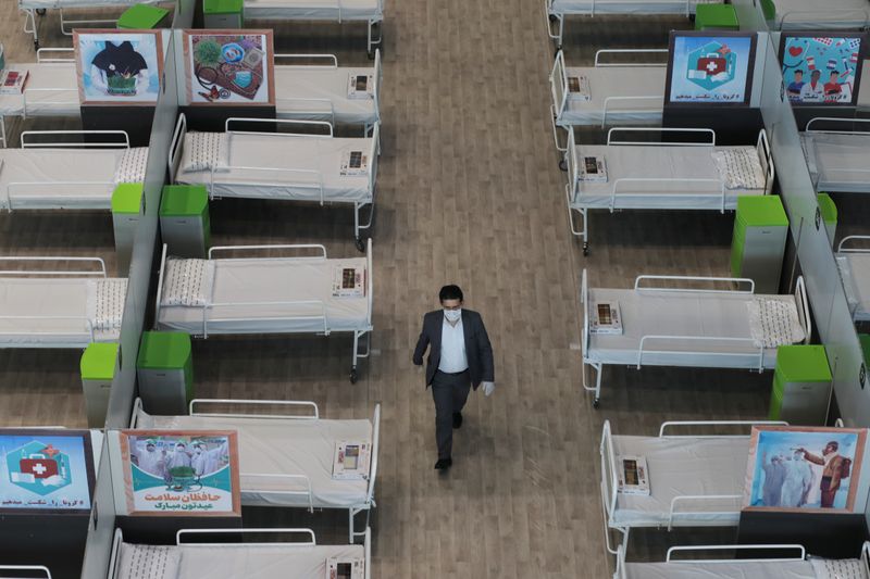 A man walks between beds at a shopping mall, one