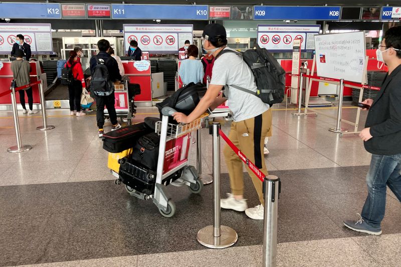 Travellers wait to check in at Beijing Capital International Airport