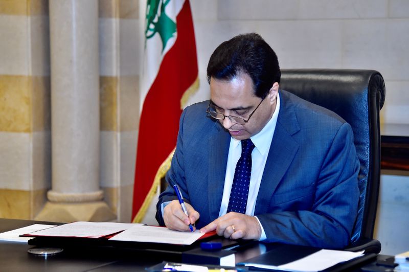 FILE PHOTO: Lebanon’s Prime Minister Hassan Diab signs request for