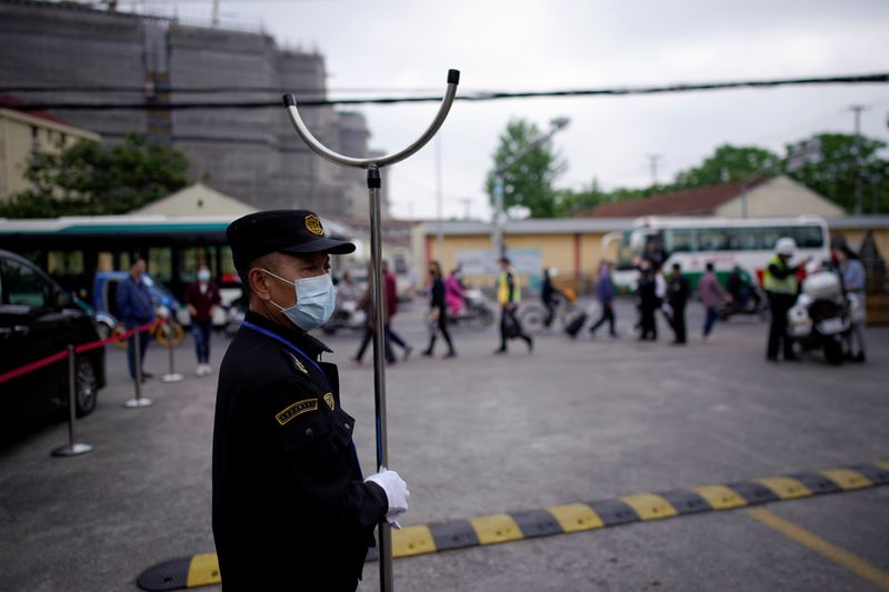 Security guard stands outside a high school in Shanghai