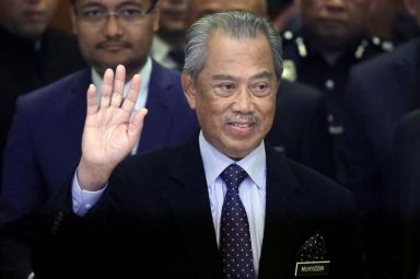 Malaysia’s Prime Minister Muhyiddin Yassin waves to reporters before his