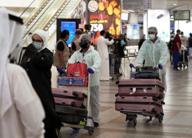 Repatriated Kuwaitis from Amman, wearing protective face masks and suits,