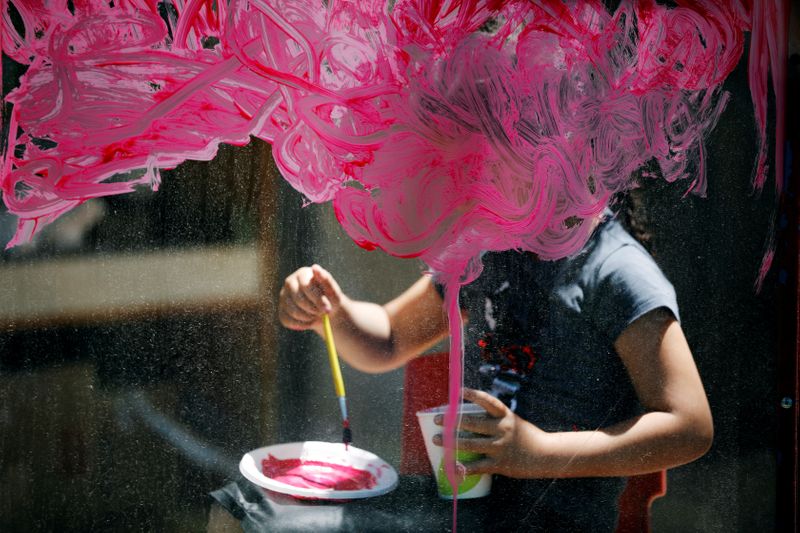 Girl paints on glass at her kindergarten in Jerusalem