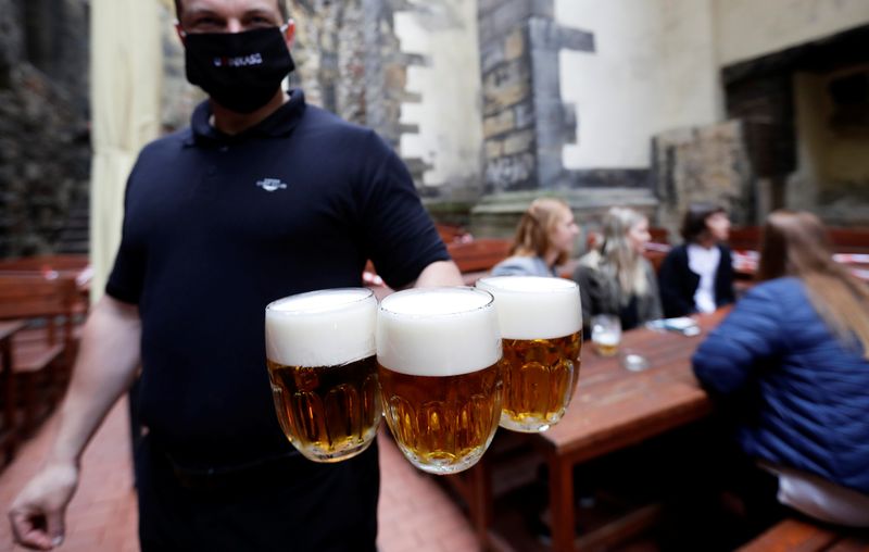 A bartender carries beers at an outdoor seating of a