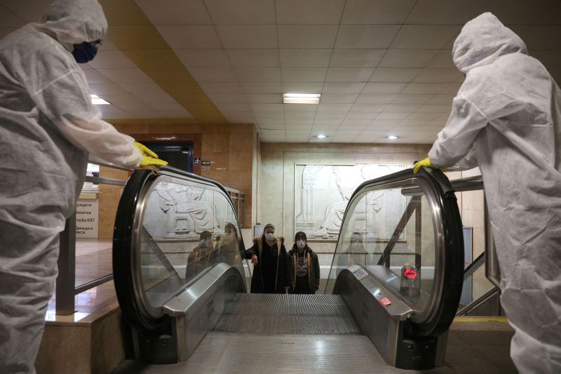 FILE PHOTO: Workers disinfect an escalator in Serdika metro station