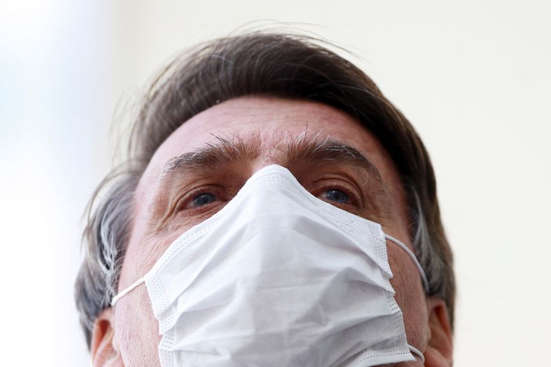 Brazil’s President Jair Bolsonaro wearing a protective mask speaks with