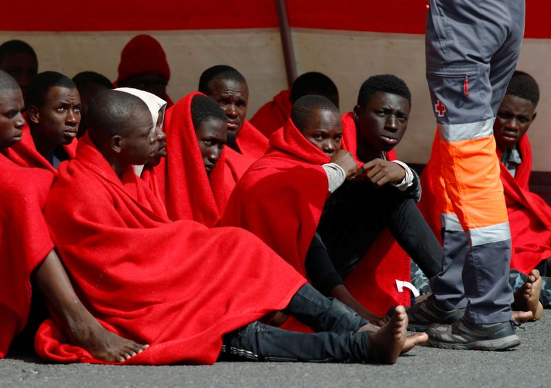 Migrants rescued in the Atlantic Ocean disembark from a Spanish
