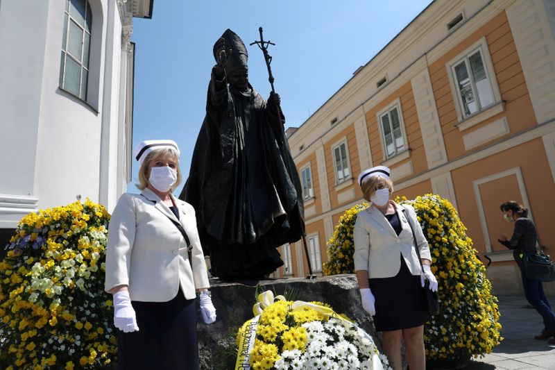 Nurses in protective masks attend a ceremony to commemorate the
