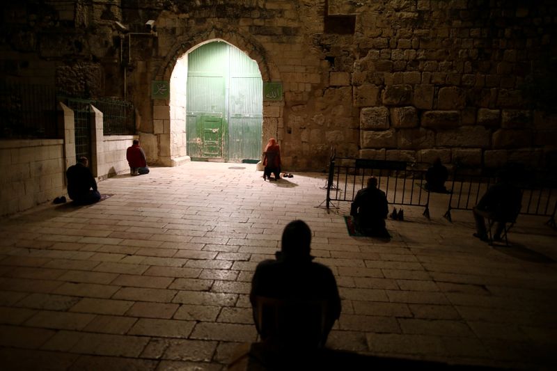 FILE PHOTO: Muslim worshippers pray near the closed gate of