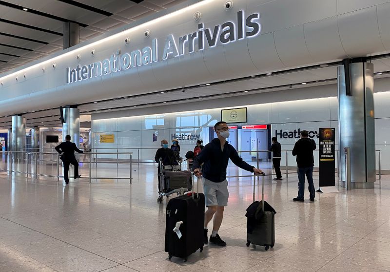 Passengers arrive from international flights at Heathrow Airport in London