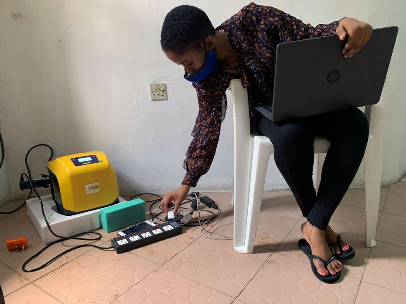 Gbemisola Olowokere, 23, plugs her phone charger to an extension