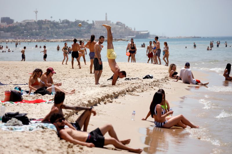 People visit a beach along the coast of the Mediterranean