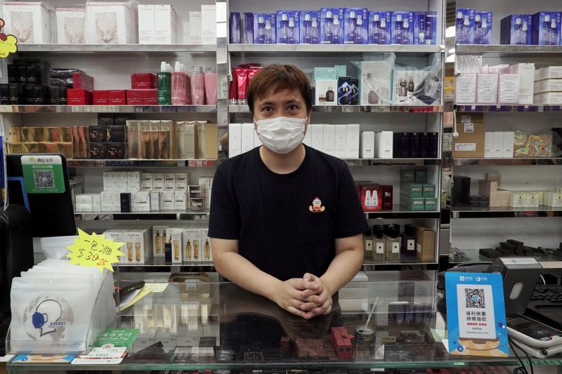 Cosmetics store owner David So poses for photo in Hong