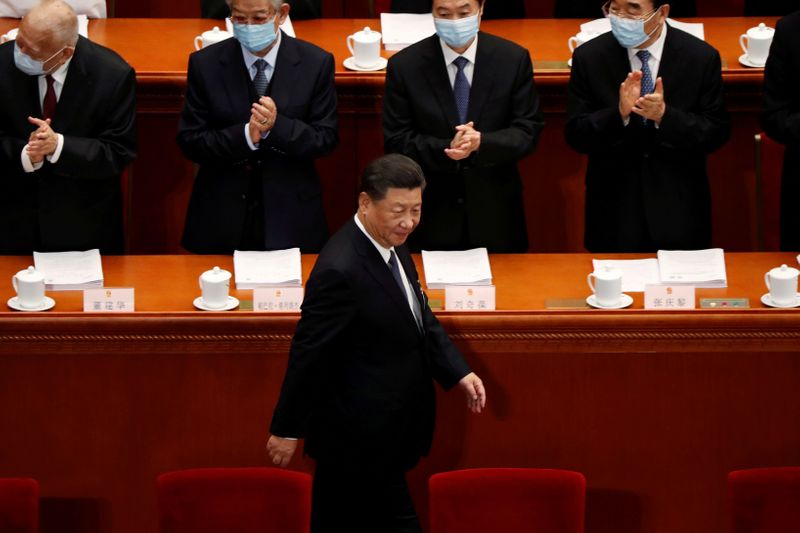 FILE PHOTO: Chinese President Xi Jinping walks past officials wearing