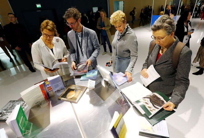 Visitors examine books at Frankfurt book fair in Frankfurt