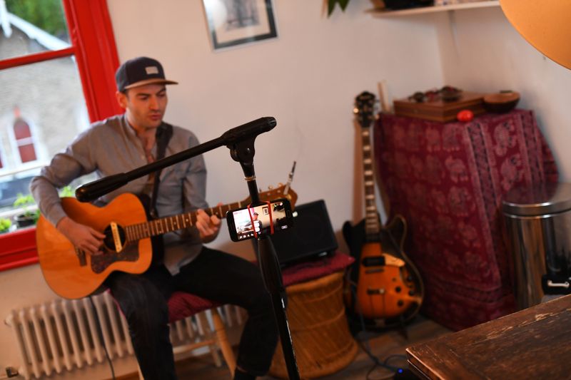 Musician Theo Bard sings as he performs an online gig
