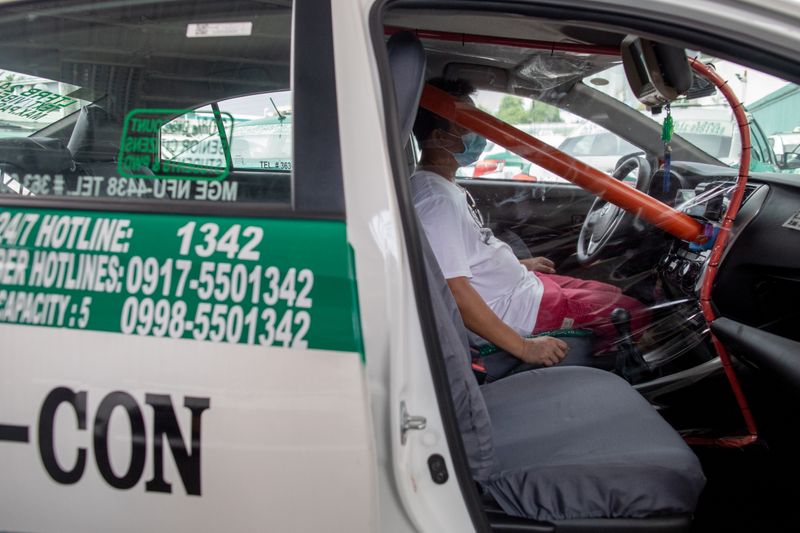 Taxis install makeshift barricades as lockdown eases in Manila