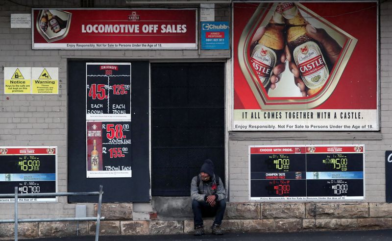 A bystander sits outside a closed liquor store during a