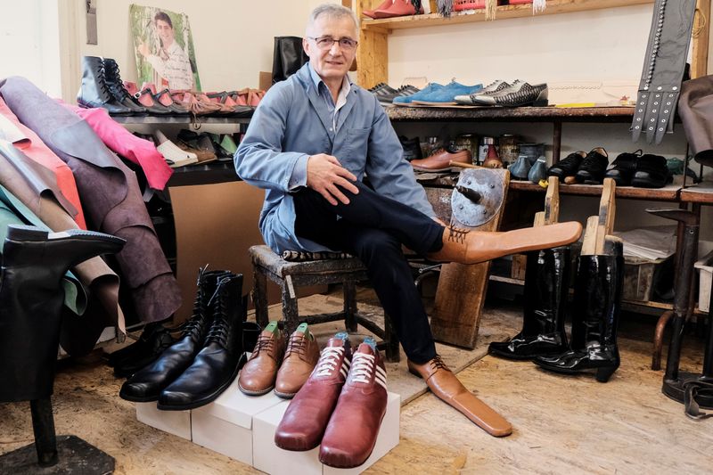 Romanian shoemaker Grigore Lup poses for a portrait while showcasing
