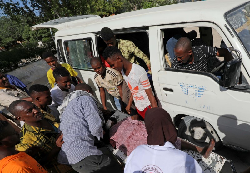 Paramedics and civilians at Madina hospital assist an injured man