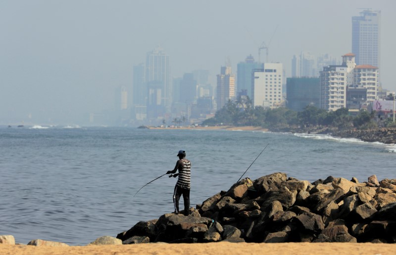 FILE PHOTO: A man fishes near a deserted beach near