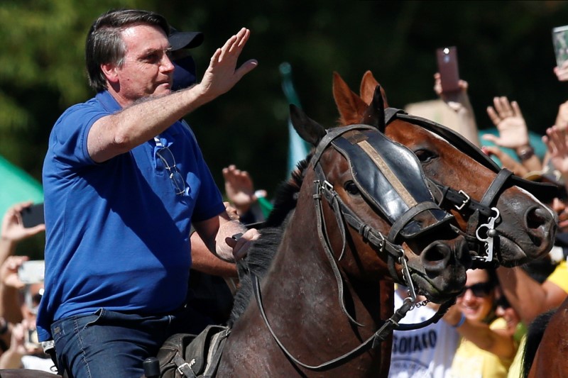 Brazil’s President Jair Bolsonaro rides a horse during a meeting