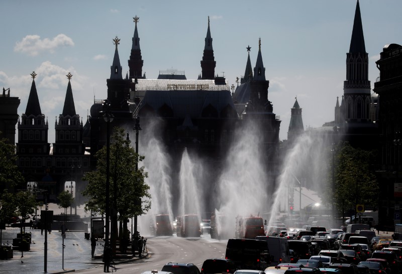 FILE PHOTO: Vehicles spray disinfectant while sanitizing a road amid