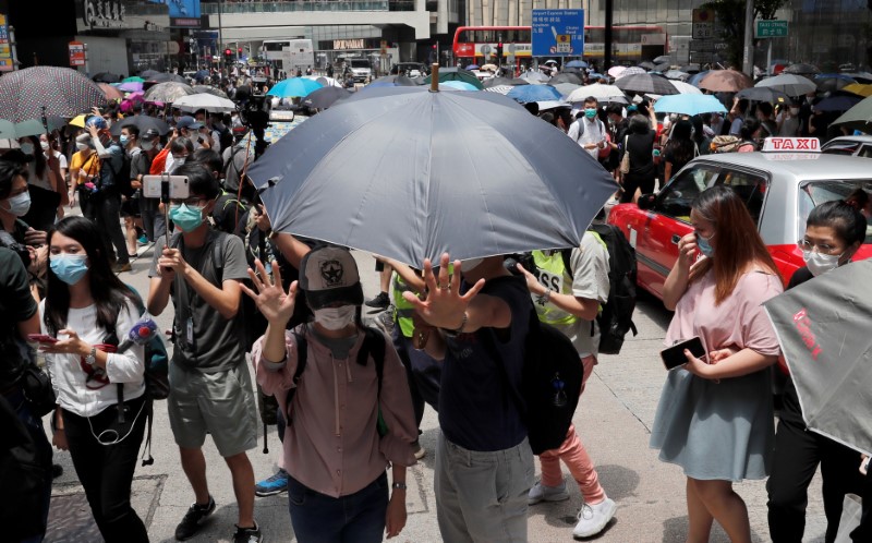 People wearing face masks take part in a protest against