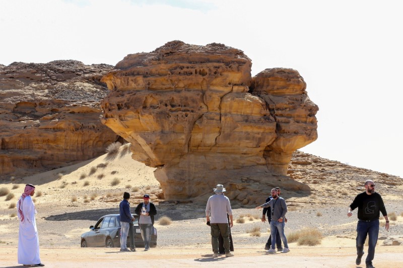 Visitors tour near Rock formations that resemble human face at