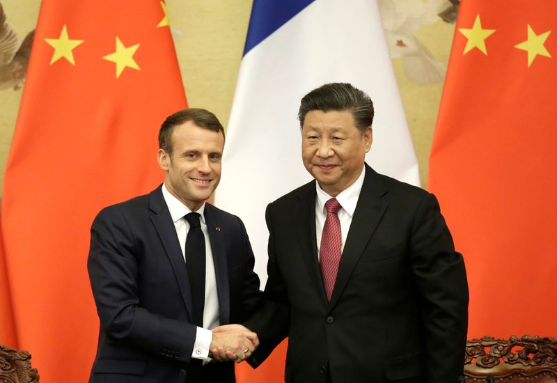 FILE PHOTO: French President Emmanuel Macron shakes hands with China’s