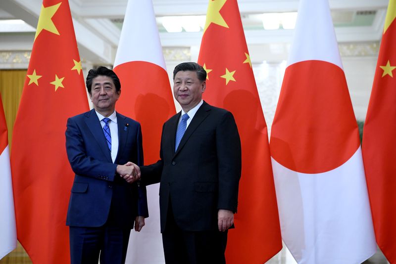 Japan’s Prime Minister Shinzo Abe shakes hands with China’s President
