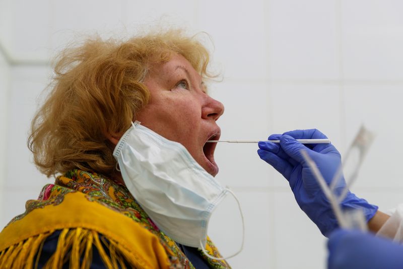 A healthcare worker takes a swab from a woman during