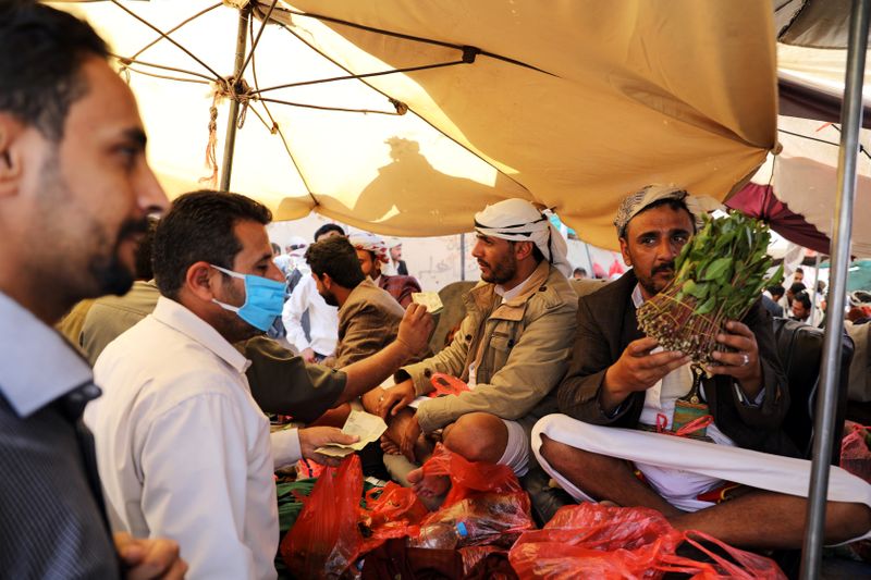 Vendor holds qat, a mild stimulant, at a qat market