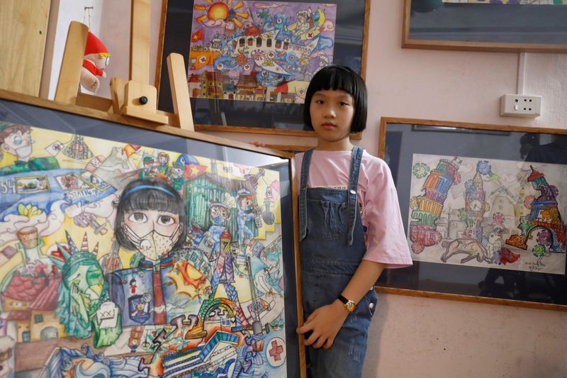 A Vietnamese school girl draws paintings about the coronavirus disease