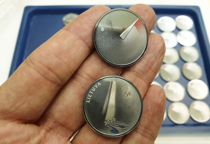 A man shows 5 Euros nominal silver coins, minted to