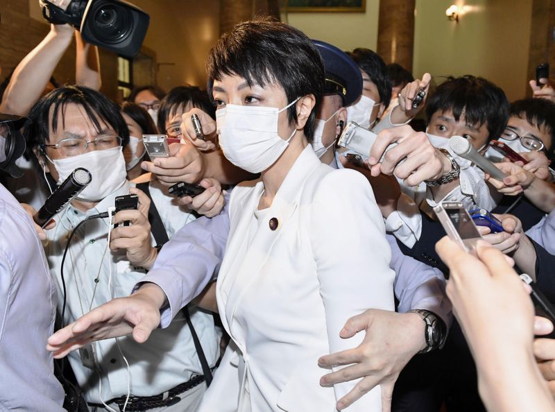 Japan’s upper house lawmaker Anri Kawai is surrounded by reporters