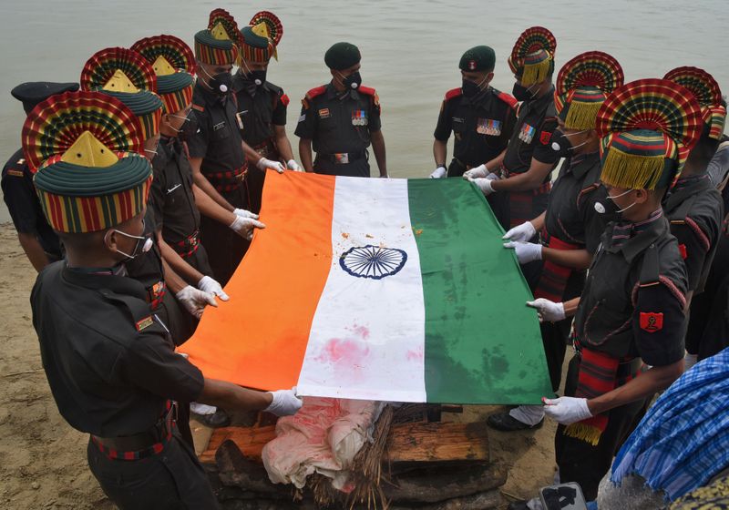Soldiers drape Indian national flag over the body of Sunil