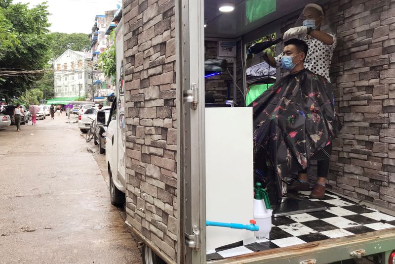 Burmese barber Ko Phyo works at his mobile hair salon