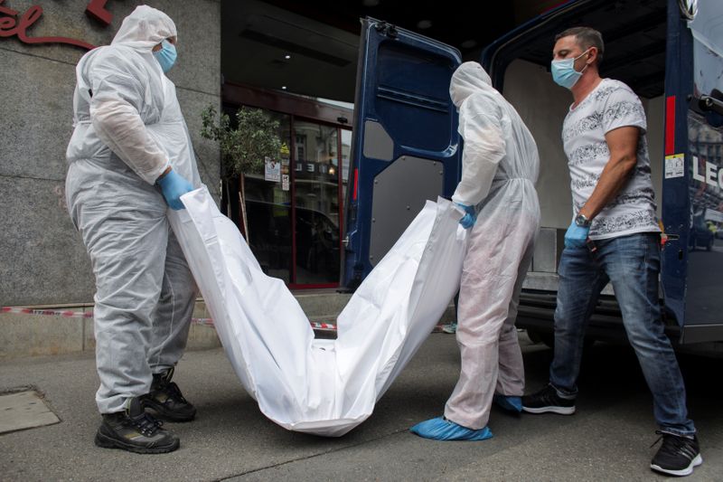 Forensic medicine staff carry a body bag, allegedly containing the