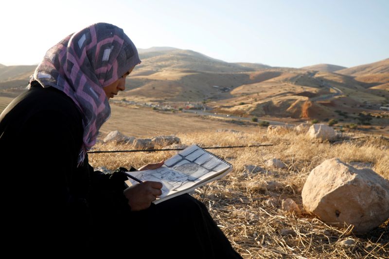 Khadeeja Bisharat, a Palestinian artist, draws in Jordan Valley in