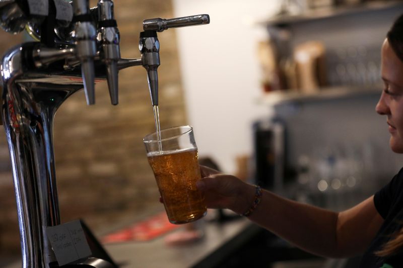 FILE PHOTO: A barmaid pours a pint at the Green