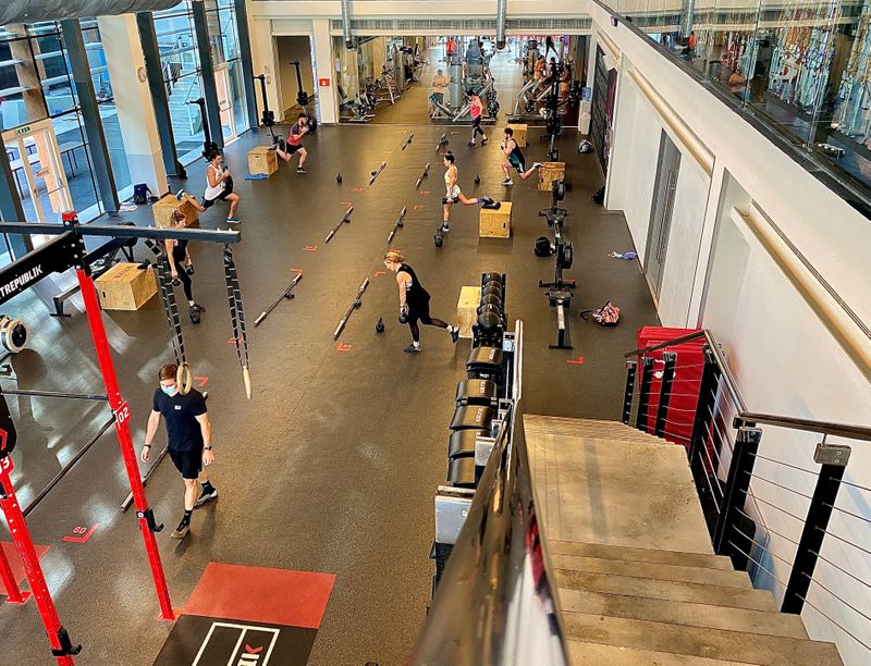 People exercise at a gym while maintaining social distancing as