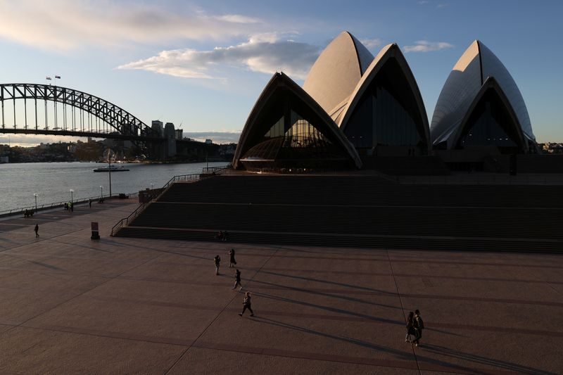 People are seen walking in front of the Sydney Opera