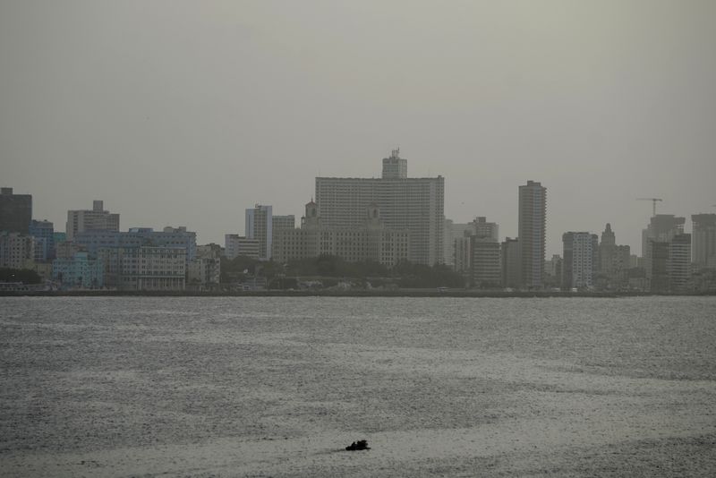 A fishing boat leaves the bay of Havana as dust