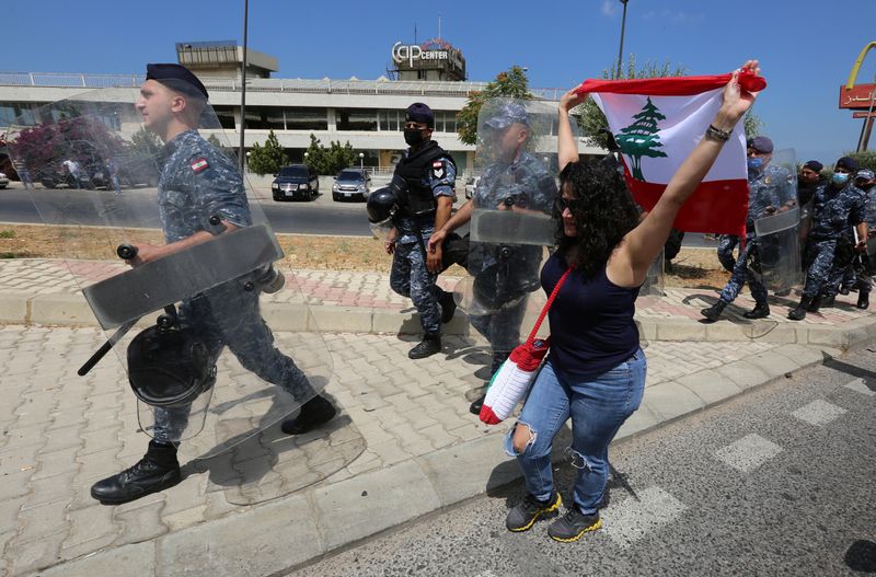 A demonstrator holds a Lebanese flag during a protest against