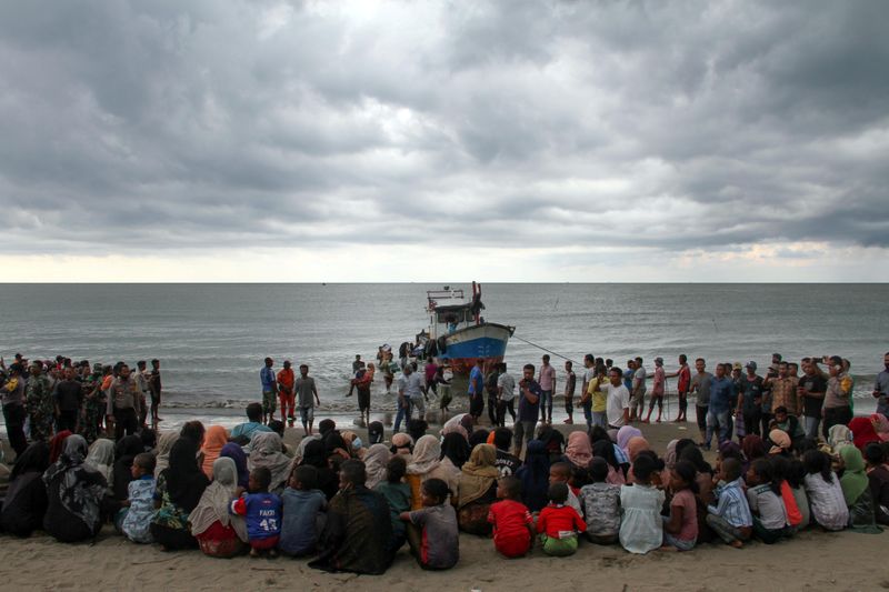 Rohingya refugees are evacuated by locals at a coast of