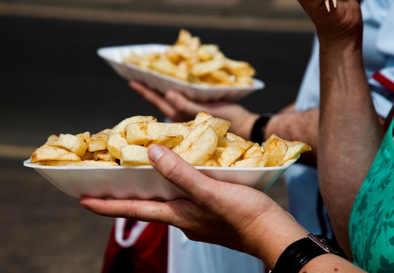 FILE PHOTO: People eat chips whilst walking along the promenade